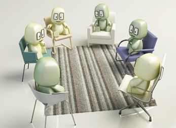 Grupo de supervisión de Arasis sentados en sillas dispuesto en círculo sobre una alfombra rayada